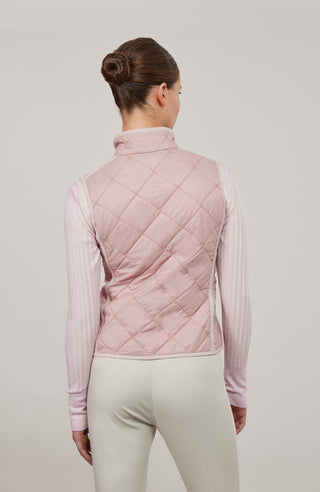 Sportliche Reiterweste Nora Quilt aus leichtem Quilt Light mit 40 g Hochdaunen-Vlies für angenehme Wärme bei minimalem Gewicht. Atmungsaktiv sowie wasser- und schmutzabweisend. Kleiner Stehkragen, mit Leinen eingefasste Nähte und hochwertige Metalldruckknöpfe prägen den klaren Look. Seitliche Taschen mit nahtfeinem Reißverschluss sorgen für Funktionalität. Das fein gesteppte italienische Nylon im klassischen Rautenmuster verleiht der Weste eine elegante, sportive Optik. Leicht verstaubar und ideal für unter