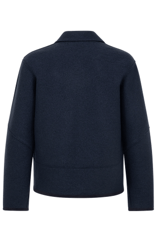 Nachhaltige Damen-Walkjacke Violet in midnight aus wärmender, mulesingfreier Schafwolle. Etwas kürzer geschnitten mit gerader, leicht kastiger Passform. Mit Reverskragen, Metalldruckknöpfen, seitlichen Taschen sowie offenkantiger Nahtverarbeitung. Alcantara-Details an Knopfleiste, Bund, Ärmeln und Innennaht. Robust, atmungsaktiv und temperaturregulierend – vielseitig kombinierbar für moderne, elegante Looks.