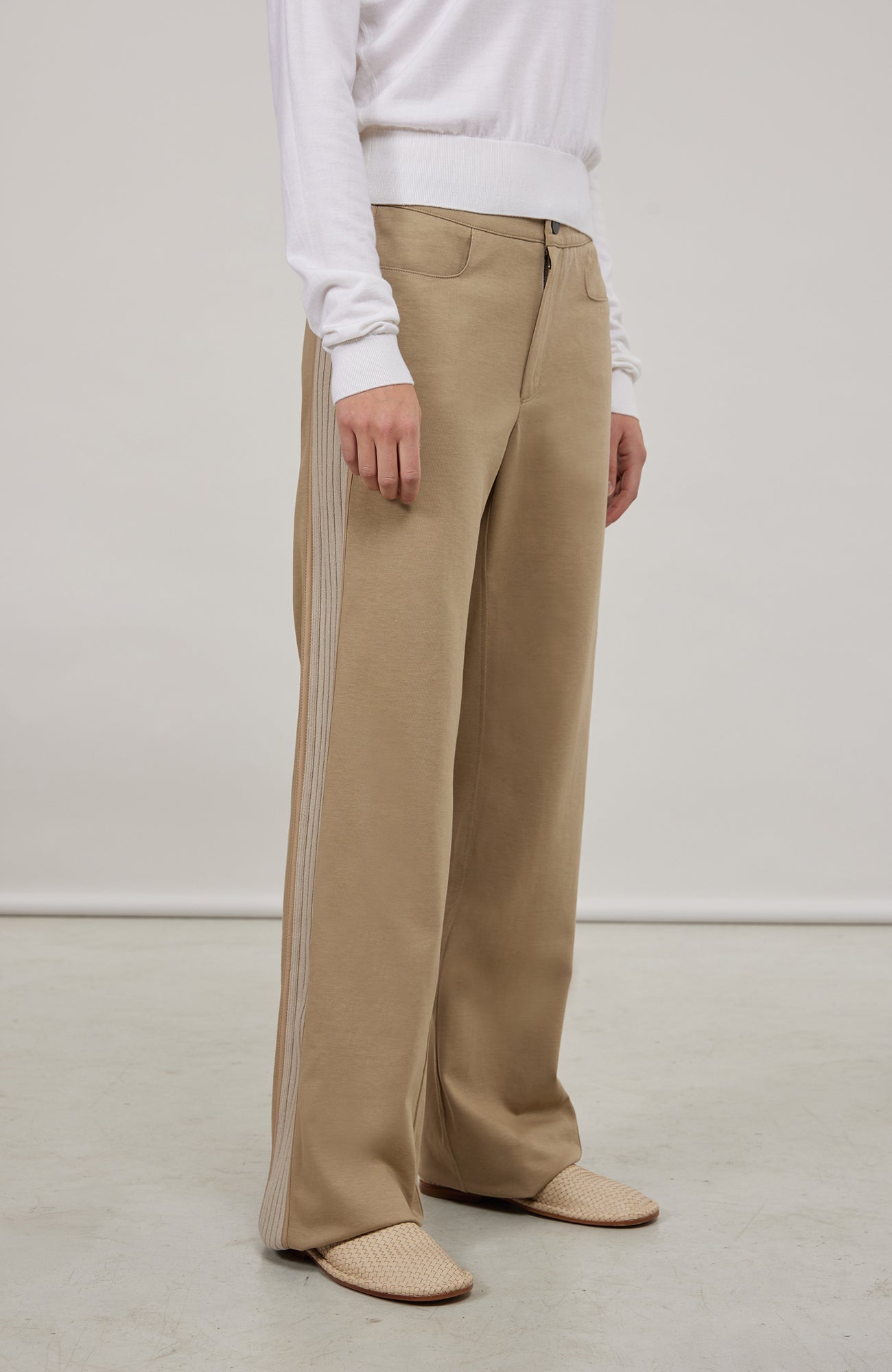 Lässige Damenhose aus hochwertiger, angenehm weicher Baumwolle mit lockerer Passform für hohen Tragekomfort und Bewegungsfreiheit. Markante Strickeinsätze und feine Paspolnähte setzen moderne, sportiv-elegante Akzente. Mit zwei praktischen Eingriffstaschen und sicherem Verschluss mit Druckknopf. Vielseitig kombinierbar – ideal für Alltag, Freizeit, Spa oder entspannte Stunden zu Hause.