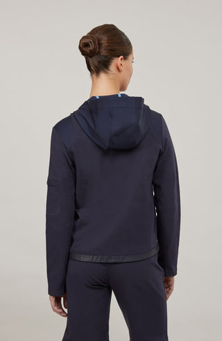 Moderne Damen-Jacke mit Kapuze aus hochwertigem Materialmix aus Baumwolle, Leinen und Elasthan. Die Jacke kombiniert atmungsaktive Baumwollpartien an Vorder- und Rückenteil mit elastischen Natural-Powerstretch-Einsätzen an Kapuze, Ärmeln und Rumpfinnenseite für hohen Tragekomfort und optimale Bewegungsfreiheit. Ausgestattet mit zwei Eingrifftaschen mit Zipp, beidseitig zu öffnendem Frontreißverschluss und edlen, waschbaren Alcantara-Lederdetails. Vielseitig kombinierbar für sportliche, urbane oder casual Lo