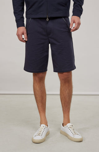 Herren-Bermuda Flynn Bermuda in midnight aus hochwertigem Baumwollmix mit Natural Powerstretch. Besonders weich und angenehm auf der Haut, mit weitem Bein für lockeren Sitz und elastischem Bund für optimalen Komfort. Zwei seitliche Eingrifftaschen mit Alcantara-Besatz sowie eine Gesäßtasche mit Reißverschluss. Vielseitig und bequem für Alltag und Freizeit.
