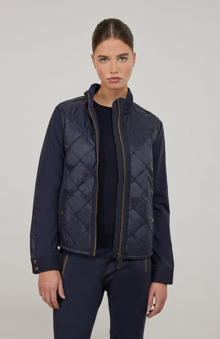 Leichte Damenjacke in moderner Quilt-Optik mit feminin-lockerer Silhouette. Der hochwertige Natural Powerstretch-Leinen-Materialmix sorgt für angenehmen Komfort und sportive Eleganz. Feine Leinen-Details an Kragen, Schultern und Ärmelabschlüssen sowie dezente Alcantara-Akzente verleihen der Jacke ihre besondere Wertigkeit. Mit kleinem Stehkragen, Reißverschluss und zwei Taschen mit Metalldruckknöpfen. Vielseitig kombinierbar – für urbane und sportive Looks.