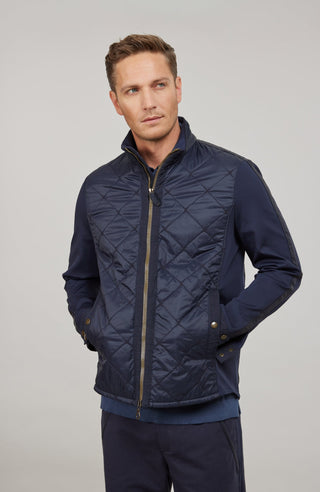 Maskuline Herrenjacke in moderner Quilt-Optik mit sportiv-lässiger Silhouette. Der exklusive Materialmix aus Natural Powerstretch und Leinen verbindet Leichtigkeit, Komfort und eine markante Struktur. Feine Leinen-Details an Kragen, Schultern und Ärmelabschlüssen sowie dezente Alcantara-Akzente verleihen der Jacke ihre charaktervolle Wertigkeit. Mit kleinem Stehkragen, Reißverschluss und zwei Taschen mit Metall-Druckknöpfen. Vielseitig kombinierbar – für urbane und sportive Looks mit modernem Anspruch.
