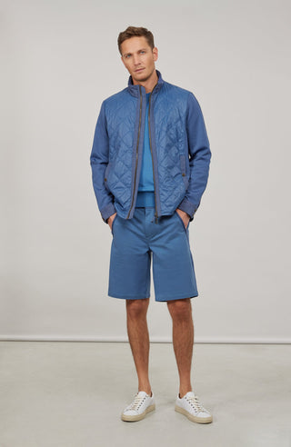 Maskuline Herrenjacke in moderner Quilt-Optik mit sportiv-lässiger Silhouette. Der exklusive Materialmix aus Natural Powerstretch und Leinen verbindet Leichtigkeit, Komfort und eine markante Struktur. Feine Leinen-Details an Kragen, Schultern und Ärmelabschlüssen sowie dezente Alcantara-Akzente verleihen der Jacke ihre charaktervolle Wertigkeit. Mit kleinem Stehkragen, Reißverschluss und zwei Taschen mit Metall-Druckknöpfen. Vielseitig kombinierbar – für urbane und sportive Looks mit modernem Anspruch.
