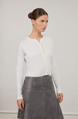 Luxuriöse Damen-Strickjacke aus Wolle, Kaschmir und Seide mit lockerem, leicht verkürztem Schnitt. Besonders weich auf der Haut, mit klassischen Rundhalsausschnitt und Rippbündchen an Ärmeln und Saum. Vielseitig kombinierbar für elegante oder lässige Looks.