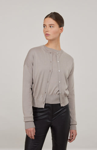 Luxuriöse Damen-Strickjacke aus Wolle, Kaschmir und Seide mit lockerem, leicht verkürztem Schnitt. Besonders weich auf der Haut, mit klassischen Rundhalsausschnitt und Rippbündchen an Ärmeln und Saum. Vielseitig kombinierbar für elegante oder lässige Looks.
