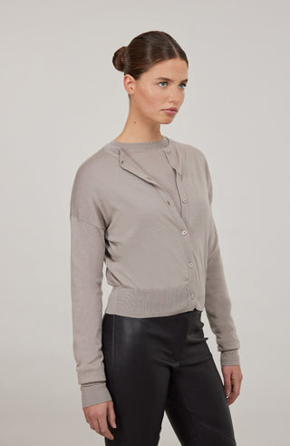 Luxuriöse Damen-Strickjacke aus Wolle, Kaschmir und Seide mit lockerem, leicht verkürztem Schnitt. Besonders weich auf der Haut, mit klassischen Rundhalsausschnitt und Rippbündchen an Ärmeln und Saum. Vielseitig kombinierbar für elegante oder lässige Looks.