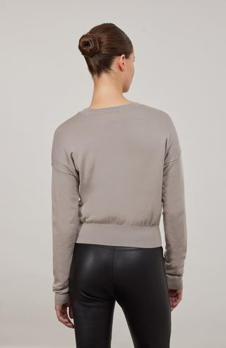 Luxuriöse Damen-Strickjacke aus Wolle, Kaschmir und Seide mit lockerem, leicht verkürztem Schnitt. Besonders weich auf der Haut, mit klassischen Rundhalsausschnitt und Rippbündchen an Ärmeln und Saum. Vielseitig kombinierbar für elegante oder lässige Looks.