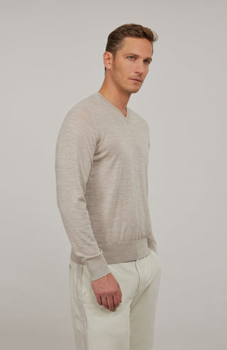 Herren-Pullover mit klassischem V-Ausschnitt aus feiner, hochwertiger Wollqualität aus Italien. Besonders weich und angenehm auf der Haut, mit zeitlosem Design und feiner Strickstruktur. Rippstrickbündchen an Ärmeln und Saum sorgen für eine optimale Passform. Vielseitig kombinierbar – elegant unter dem Sakko oder lässig zur Jeans.
