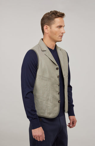 Ärmelloses Herren-Gilet aus hochwertigem Baumwoll-Leinen-Mix mit angenehm weichem Griff und dezenter melierter Optik. Moderner, neu interpretierter Schnitt mit maskuliner Silhouette und markantem Reverskragen. Mit Knopfleiste, aufgesetzten Brust- und Fronttaschen sowie kleiner Eingrifftasche links. Abgerundeter Saum für dynamische Linien und eingefasste Baumwollbänder an Saum, Taschen und Seitennähten als dezente Details. Vielseitig kombinierbar und als maskulines Fashion-Statement geeignet.