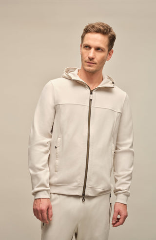 Vorderansicht der Herrenjacke "Thomas" von einem Model getragen, in der Farbe weiß. Die Jacke besteht aus umweltfreundlichem Biodegradable Fleece und zeichnet sich durch einen sportlichen Schnitt, einen verstellbaren Nylon-Kapuzenkragen und praktische Reißverschlusstaschen aus. Ideal für alle Jahreszeiten, kombiniert sie Funktionalität mit modernem Design