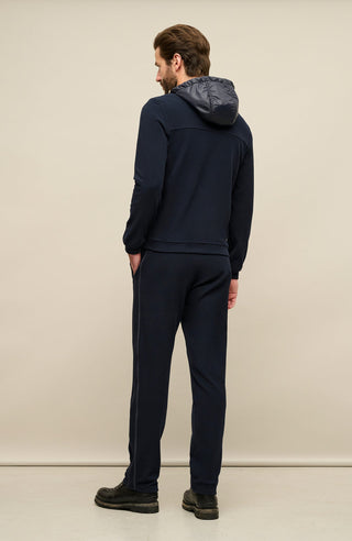 Rückansicht der Herrenjacke „Thomas“ von einem Model getragen in Dunkelblau (1630 Midnight). Die Jacke aus nachhaltigem Biodegradable Fleece zeigt den minimalistischen Schnitt, den verstellbaren Nylon-Kapuzenkragen und den Zweiwegereißverschluss, ideal für alle Jaheszeiten