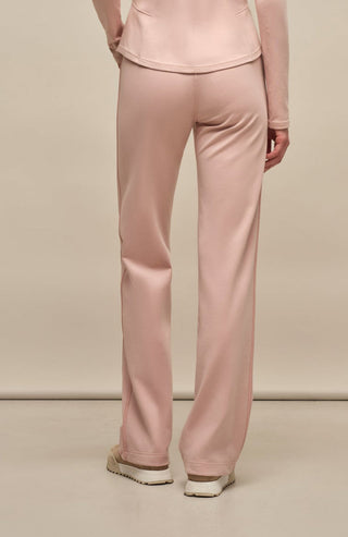 Model trägt die Damen-Powerstretch-Hose „Inga“ in der Farbe Dusty Rose – Rückansicht, zeigt die gerade geschnittene Hose ohne Taschen und Reißverschlüsse, mit elastischem Bund und einem schlichten, funktionalen Design für maximalen Tragekomfort und Bewegungsfreiheit