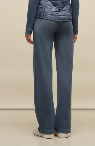 Model trägt die Damen-Powerstretch-Hose „Inga“ in der Farbe Denim – Rückansicht, zeigt die gerade geschnittene Hose ohne Taschen und Reißverschlüsse, mit elastischem Bund und schlichtem Design, das für maximale Bewegungsfreiheit und Tragekomfort sorgt