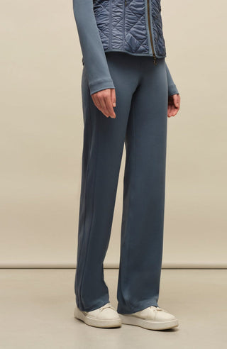Model trägt die Damen-Powerstretch-Hose „Inga“ in der Farbe Denim – seitliche Perspektive, zeigt die gerade geschnittene Hose ohne Taschen und Reißverschlüsse, mit elastischem Bund und schlichtem Design für optimale Bewegungsfreiheit und Komfort