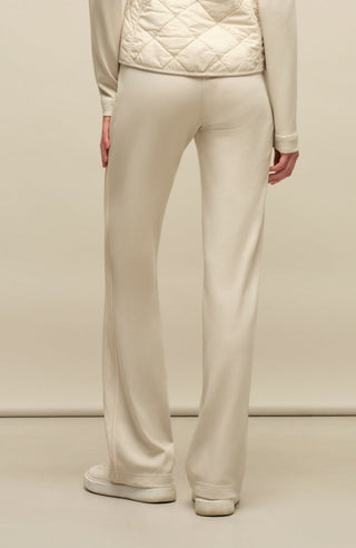 Model trägt die Damen-Powerstretch-Hose „Inga“ in der Farbe Sandstone – Rückansicht, zeigt den geraden, leggingsähnlichen Schnitt ohne Taschen und Reißverschlüsse, mit elastischem Bund und schlichtem Design für hohen Tragekomfort und Bewegungsfreiheit im Alltag und beim Sport