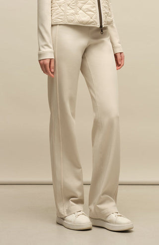 Model trägt die Damen-Powerstretch-Hose „Inga“ in der Farbe Sandstone – seitliche Ansicht, zeigt den geraden, leggingsähnlichen Schnitt ohne Taschen und Reißverschlüsse, mit elastischem Bund; ideal für sportliche Aktivitäten und den Alltag in Frühling und Sommer