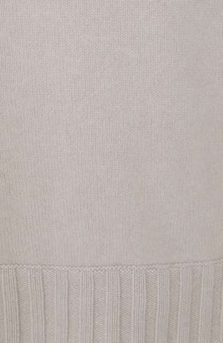 Detailaufnahme des Saums und unteren Bereichs eines Herren-Kaschmirpullovers von Frauenschuh, Modell „Aiden“ (Artikelnummer WS_10-0) in der Farbe Beige. Der fein gestrickte Rippbündchen-Saum aus 100 % Kaschmir hebt sich durch seine robuste Struktur vom glatt gestrickten Körper des Pullovers ab. Das Bild zeigt die hochwertige Verarbeitung und die luxuriöse Materialqualität, typisch für die alpine Premium-Mode von Frauenschuh.