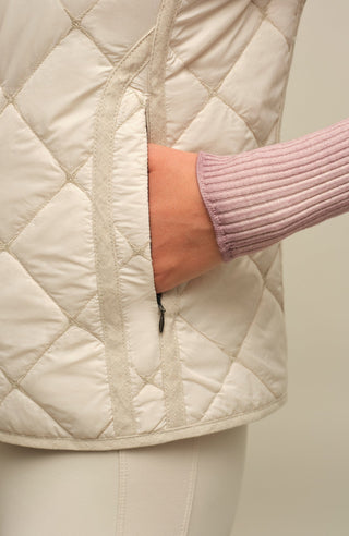 Sportliche Reiterweste Nora Quilt aus leichtem Quilt Light mit 40 g Hochdaunen-Vlies für angenehme Wärme bei minimalem Gewicht. Atmungsaktiv sowie wasser- und schmutzabweisend. Kleiner Stehkragen, mit Leinen eingefasste Nähte und hochwertige Metalldruckknöpfe prägen den klaren Look. Seitliche Taschen mit nahtfeinem Reißverschluss sorgen für Funktionalität. Das fein gesteppte italienische Nylon im klassischen Rautenmuster verleiht der Weste eine elegante, sportive Optik. Leicht verstaubar und ideal für unter
