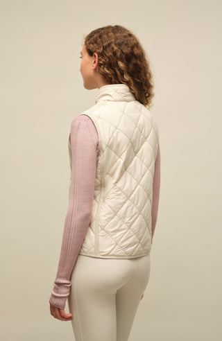 Sportliche Reiterweste Nora Quilt aus leichtem Quilt Light mit 40 g Hochdaunen-Vlies für angenehme Wärme bei minimalem Gewicht. Atmungsaktiv sowie wasser- und schmutzabweisend. Kleiner Stehkragen, mit Leinen eingefasste Nähte und hochwertige Metalldruckknöpfe prägen den klaren Look. Seitliche Taschen mit nahtfeinem Reißverschluss sorgen für Funktionalität. Das fein gesteppte italienische Nylon im klassischen Rautenmuster verleiht der Weste eine elegante, sportive Optik. Leicht verstaubar und ideal für unter