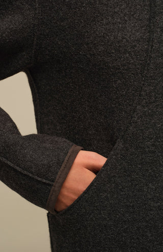 Nachhaltige Damen-Walkjacke Violet in Cliff aus wärmender, mulesingfreier Schafwolle. Etwas kürzer geschnitten mit gerader, leicht kastiger Passform. Mit Reverskragen, Metalldruckknöpfen, seitlichen Taschen sowie offenkantiger Nahtverarbeitung. Alcantara-Details an Knopfleiste, Bund, Ärmeln und Innennaht. Robust, atmungsaktiv und temperaturregulierend – vielseitig kombinierbar für moderne, elegante Looks.