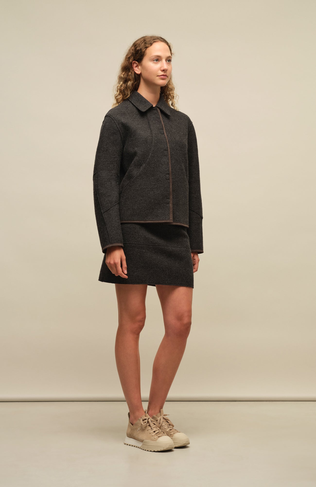 Nachhaltige Damen-Walkjacke Violet in Cliff aus wärmender, mulesingfreier Schafwolle. Etwas kürzer geschnitten mit gerader, leicht kastiger Passform. Mit Reverskragen, Metalldruckknöpfen, seitlichen Taschen sowie offenkantiger Nahtverarbeitung. Alcantara-Details an Knopfleiste, Bund, Ärmeln und Innennaht. Robust, atmungsaktiv und temperaturregulierend – vielseitig kombinierbar für moderne, elegante Looks.