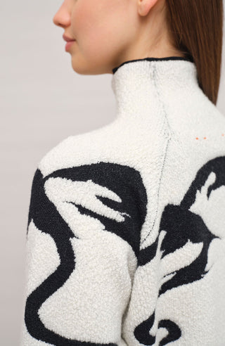 Vorderansicht eines Damenpullovers aus 100 % extrafeiner Merinowolle, Modell „Chatel-ME“ in der Farbe Grau. Die Vorderseite zeigt ein kunstvoll gestaltetes Jacquard-Motiv aus skizzierten Berglandschaften, urbanen Elementen und dynamischen Skifahrern. Das hochwertige Merinogarn – leicht, weich und angenehm auf der Haut – wird in Italien produziert und auf modernsten Maschinen verarbeitet. Die Kombination aus künstlerischem Design & technischer Strickkunst macht den Pullover besonders stilvoll
