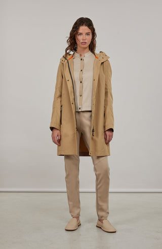 Damen-Knielanger Mantel aus Outdoor Cotton, wasser- und windabweisend, gerade Passform mit schmaler Silhouette, Stehkragen und weitenregulierbare Kapuze, Knopfleiste mit verdecktem Zwei-Wege-Zipper, Ripsband an Ärmelabschlüssen und Saum, seitliche Taschen mit markantem Zipper. In der Farbe Beige-Braun (Farbe: caramel).