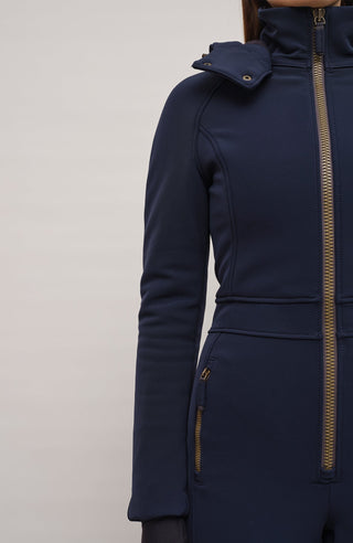 Performance Ski-Overall Kate-S aus Schöller Softshell, enganliegende Passform, Taillenbetonung durch angedeuteten Gürtel, abnehmbare Kapuze, Oberkörper gefüttert, markanter Zip, zwei Taschen mit markantem Zip, Skipasstasche mit nahtfeinem Zip, klassische Frauenschuh Features wie Kantenschutz aus Alcantara-Leder, enganliegende Ärmelbündchen und Schneefang. Robustes, elastisches Material, wasser- und windabweisend, ideal für die Skipiste. In der Farbe Dunkelblau (Farbe: midnight)