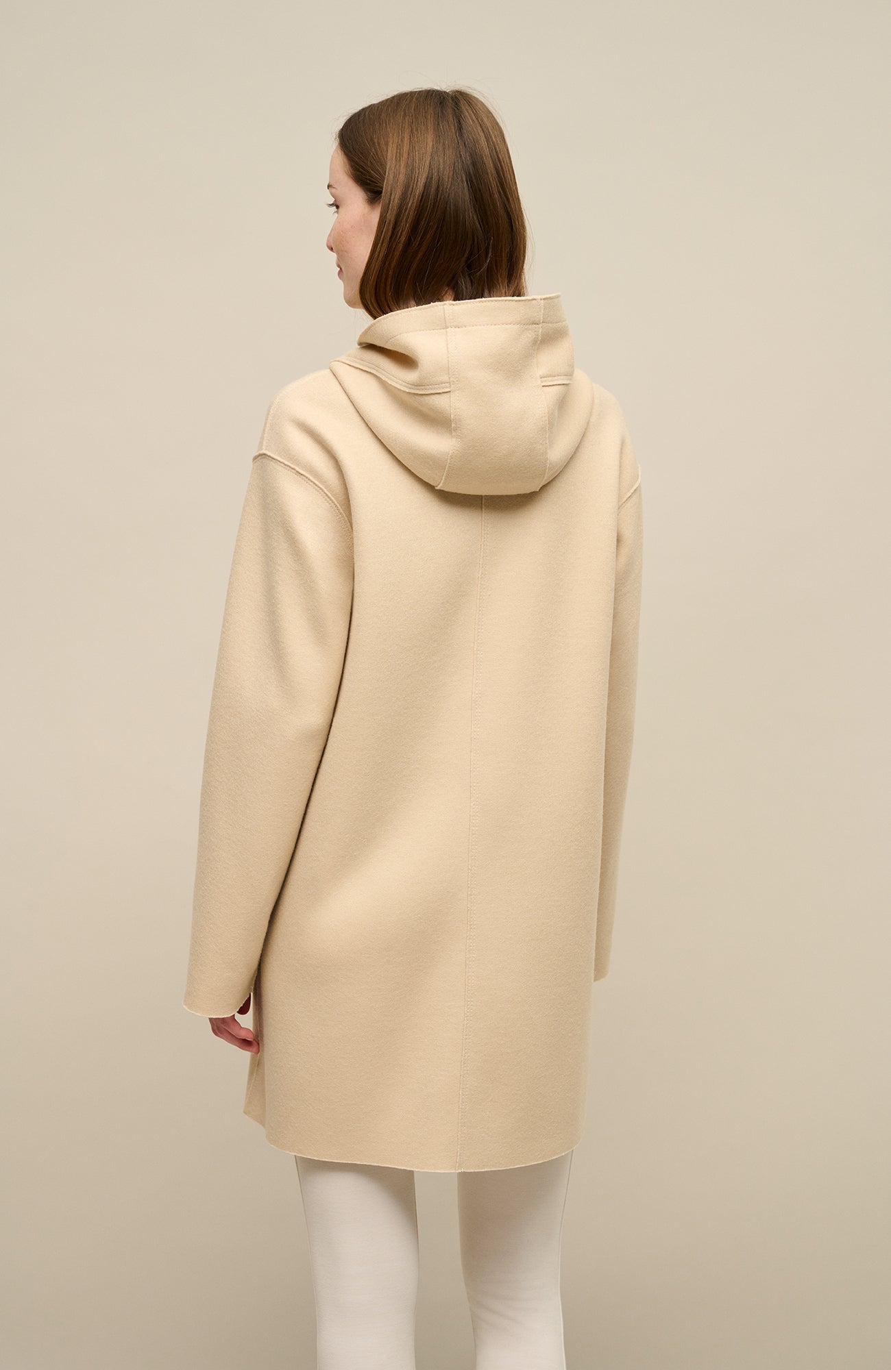 Lässiger 2-in-1 Wendekurzmantel Olivia-WD aus Wool Double in Bi-Color-Optik, gerade legere Passform mit leichtem Oversize Look, offenkantige Nahtverarbeitung, angeschnittene Kapuze, überschnittene Schulterpartie, verdeckte handangenähte Metalldruckknöpfe und zwei aufgesetzte Taschen. In der Farbe Beige (Farbe: caramel)